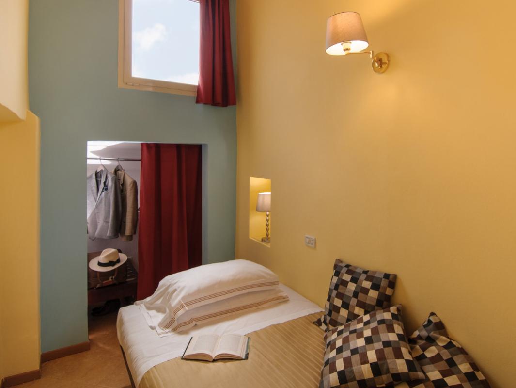 Cozy bedroom with wardrobe and high window.