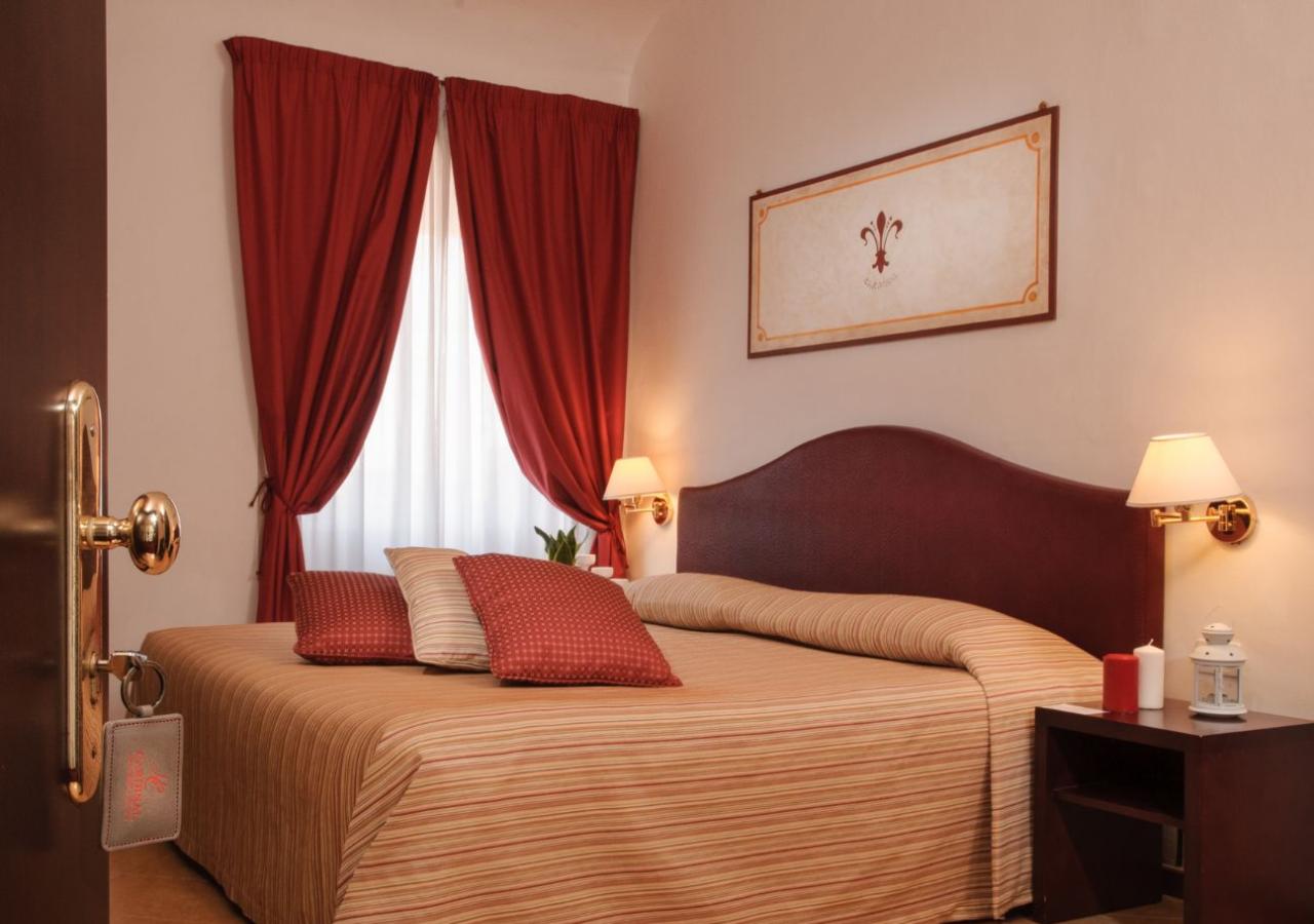 Camera accogliente con letto matrimoniale, tende rosse e illuminazione calda.