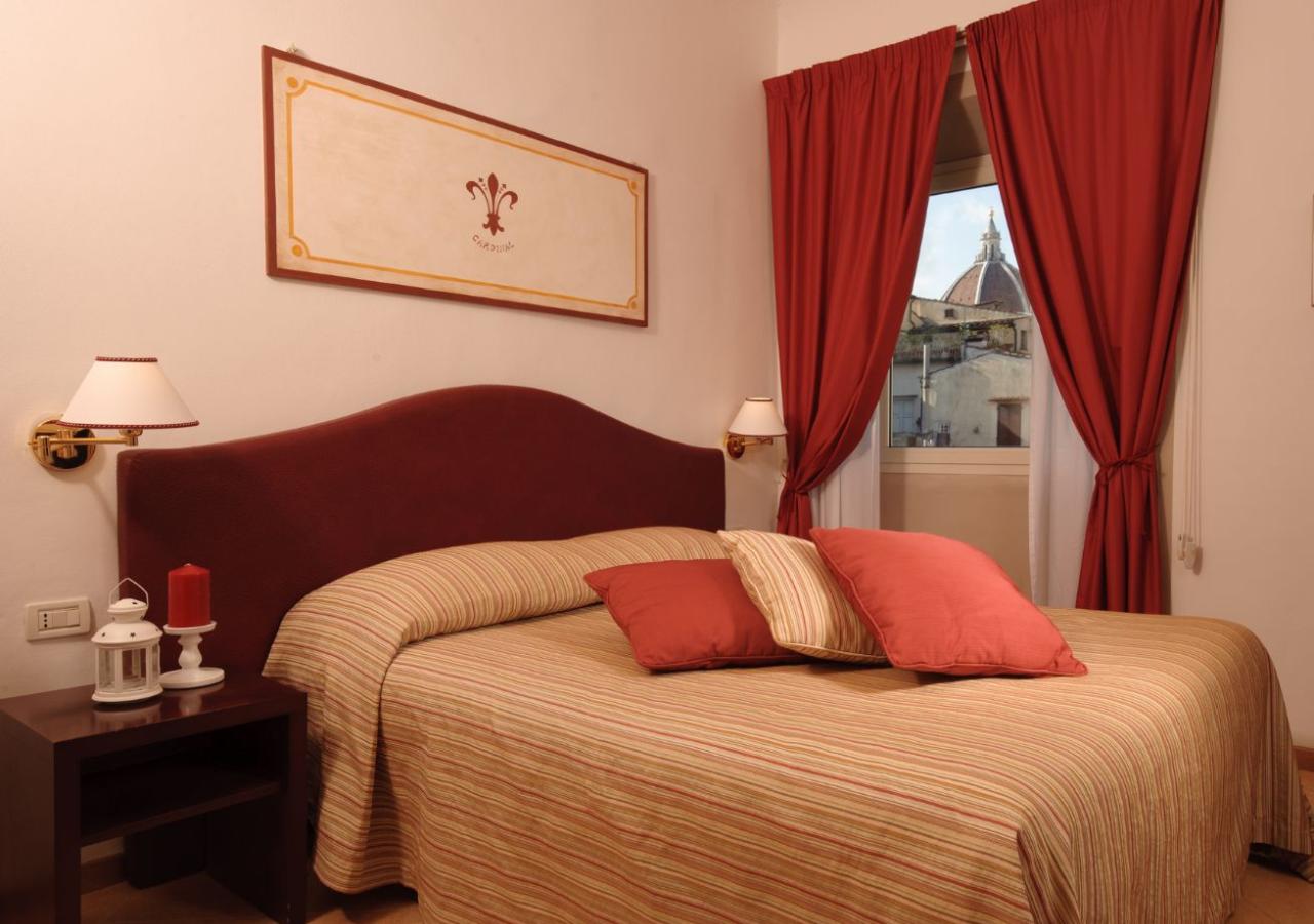 Camera da letto con vista sulla cupola, decorazioni rosse e beige.