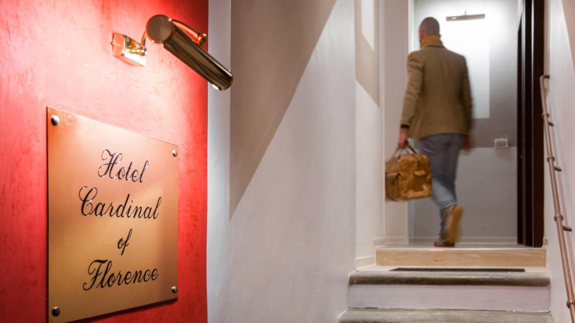 Uomo entra nell'Hotel Cardinal di Firenze con una borsa.