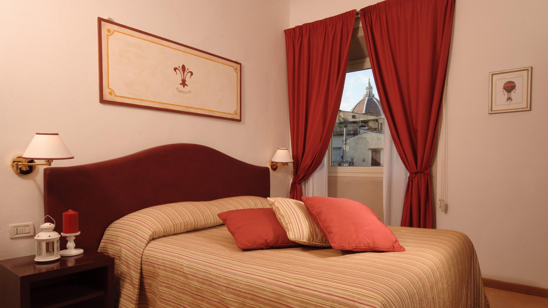 Cozy room with a double bed and a view of a historic dome.