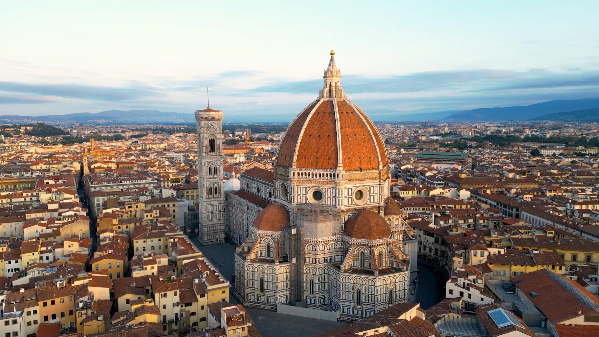 Vista aerea del Duomo di Firenze e della città circostante al tramonto.